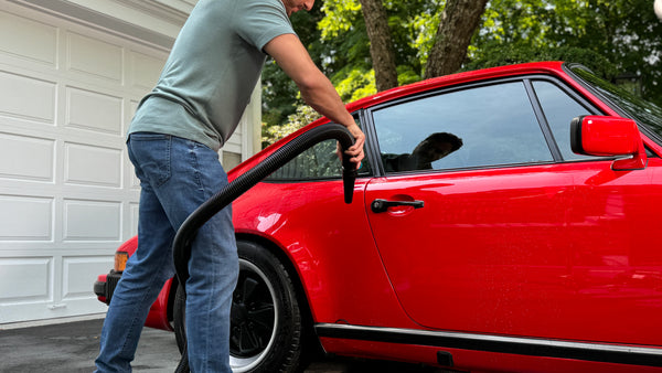 Person using the Air Force Master Blaster Car Dryer on a red sports car, demonstrating high-performance air blower for car drying.