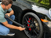 Detailer drying black Porsche wheel with the Master Blaster Car Dryer, showcasing precise airflow and car blow dryer efficiency.