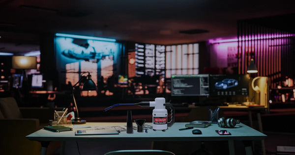 DataVac Electric Duster (ED-500) placed on a modern gaming desk with accessories, surrounded by RGB lighting, computer monitors, and gaming gear in a tech-inspired workspace.