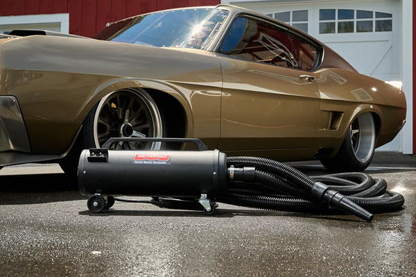 MetroVac Master Blaster Revolution car dryer on wet pavement in front of a custom bronze muscle car, ideal for professional automotive detailing.