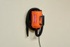 Orange MetroVac Air Force® Commander® Pet Dryer mounted on a wall with coiled hose for convenient grooming station storage.